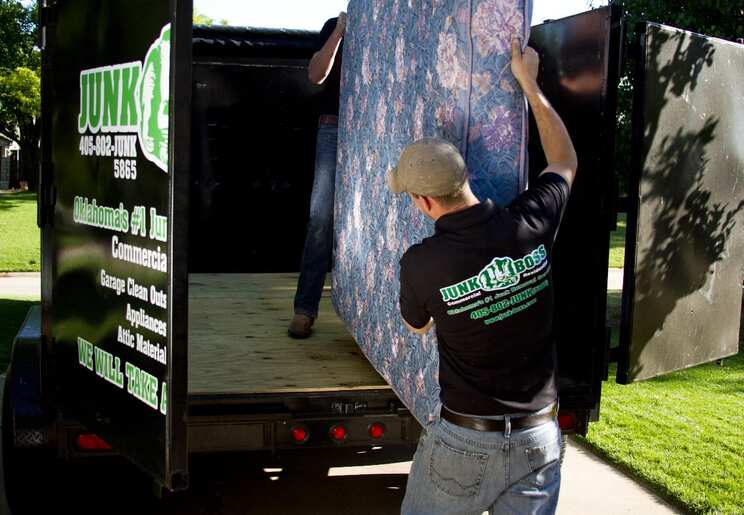 Junk Boss team removing a mattress during a residential junk removal job in Oklahoma City, OK.