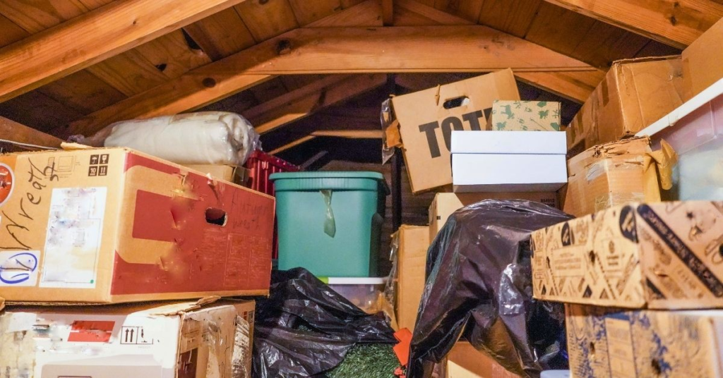 Cluttered attic filled with old boxes and storage bins ready for junk removal in Oklahoma City.