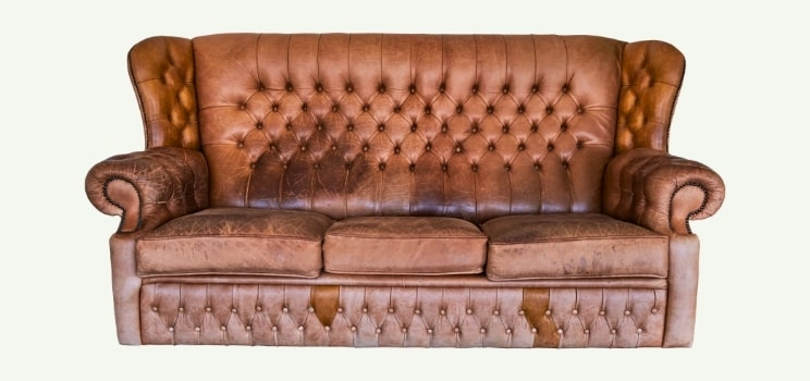 Old brown leather couch ready for furniture removal in Oklahoma City.