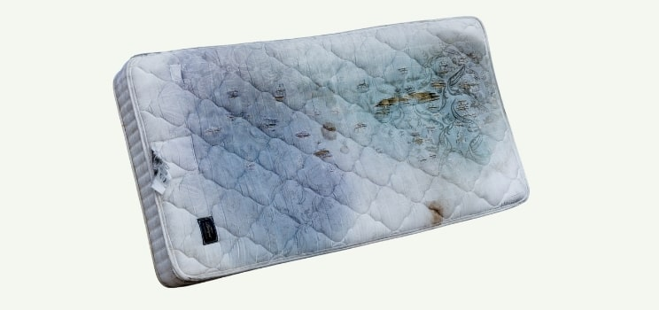 Old stained mattress ready for pickup during mattress and bed removal in Oklahoma City.