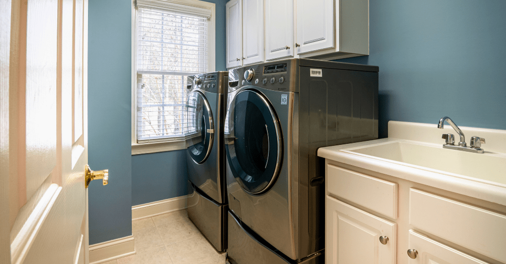 Old broken washer and dryer in a clean Oklahoma City laundry room ready for removal and disposal